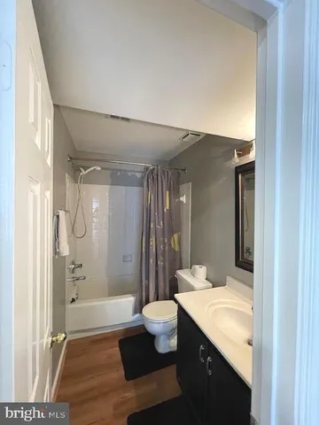 a bedroom with a large bed and wooden floor