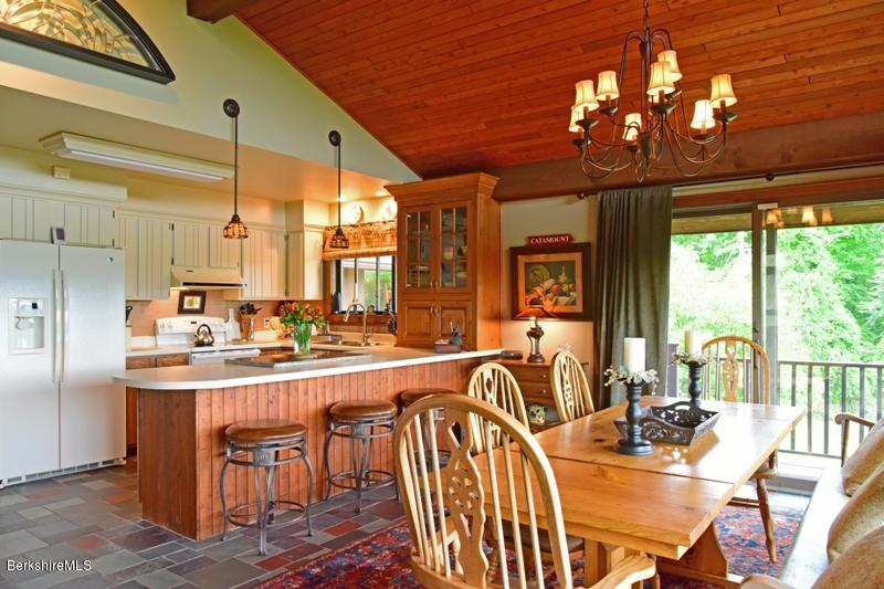 83 Sky Farm Road Copake, NY 12516 - Photo 11 of 38 a view of a dining room with furniture a chandelier and large windows