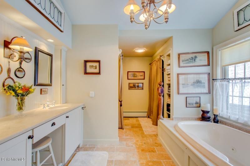 83 Sky Farm Road Copake, NY 12516 - Photo 22 of 38 a spacious bathroom with a sink a mirror a bathtub and shower
