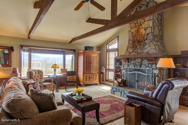 83 Sky Farm Road Copake, NY 12516 - Photo 7 of 38 a living room with furniture a fireplace and a floor to ceiling window