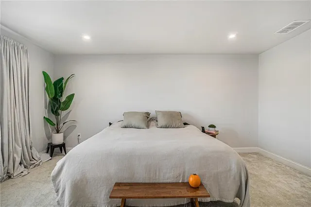 a bedroom with a bed and potted plant