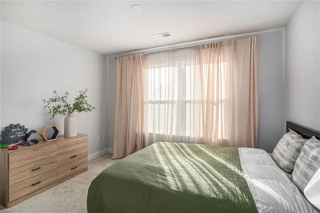 a bedroom with a bed potted plant and a window