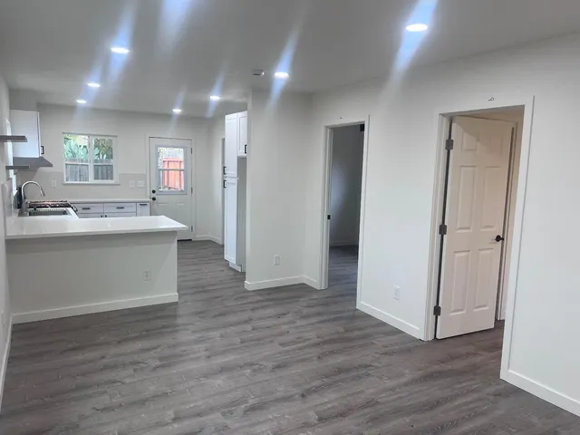 a kitchen with stainless steel appliances granite countertop a sink stove and wooden floor