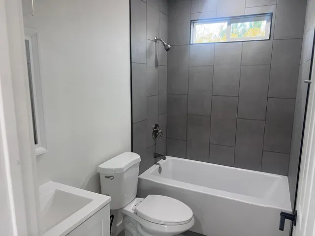 a white toilet and tub sitting next to a bathroom sink