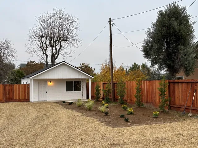 a view of a house with backyard and wooden fence