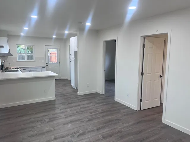 a view of kitchen with stainless steel appliances granite countertop cabinets and wooden floor