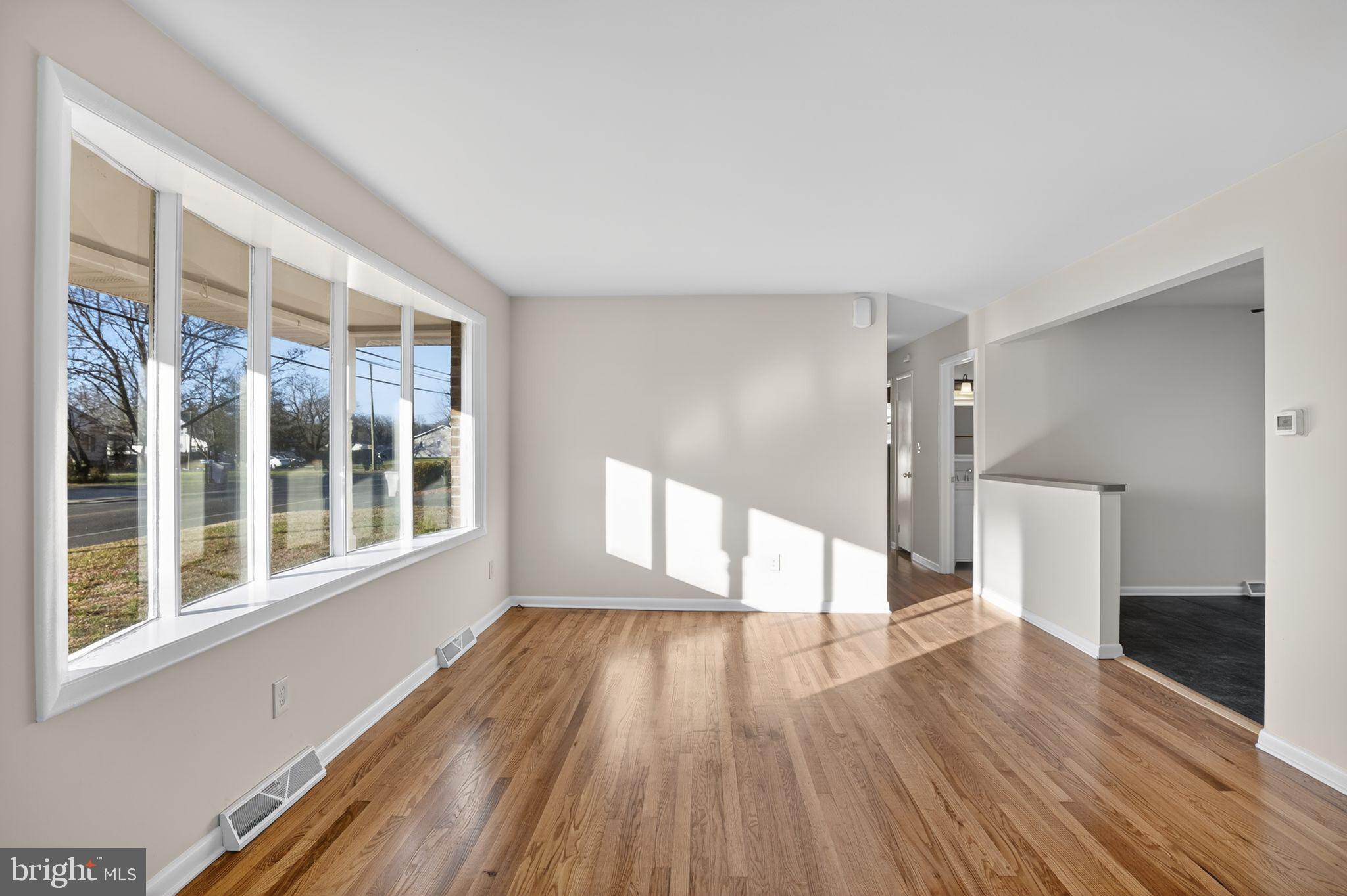 462 East Elmer Road Vineland, NJ 08360 - Photo 4 of 30 a view of an empty room with wooden floor and a window