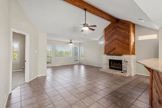 an empty room with fireplace and windows