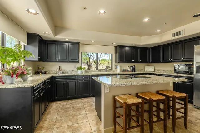 a kitchen with stainless steel appliances granite countertop a stove top oven a sink dishwasher and cabinets