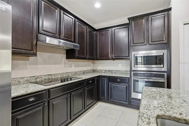 a kitchen with granite countertop stainless steel appliances and wooden cabinets