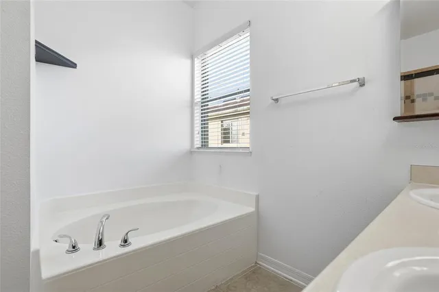 a bathroom with bathtub and window