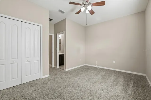 an empty room with a chandelier fan