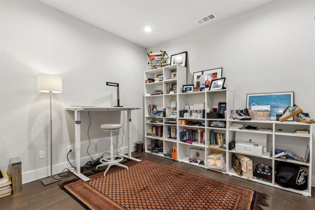 4109 Maison Ridge Dallas, TX 75219 - Photo 23 of 39 a room with a book shelf and a wooden floor