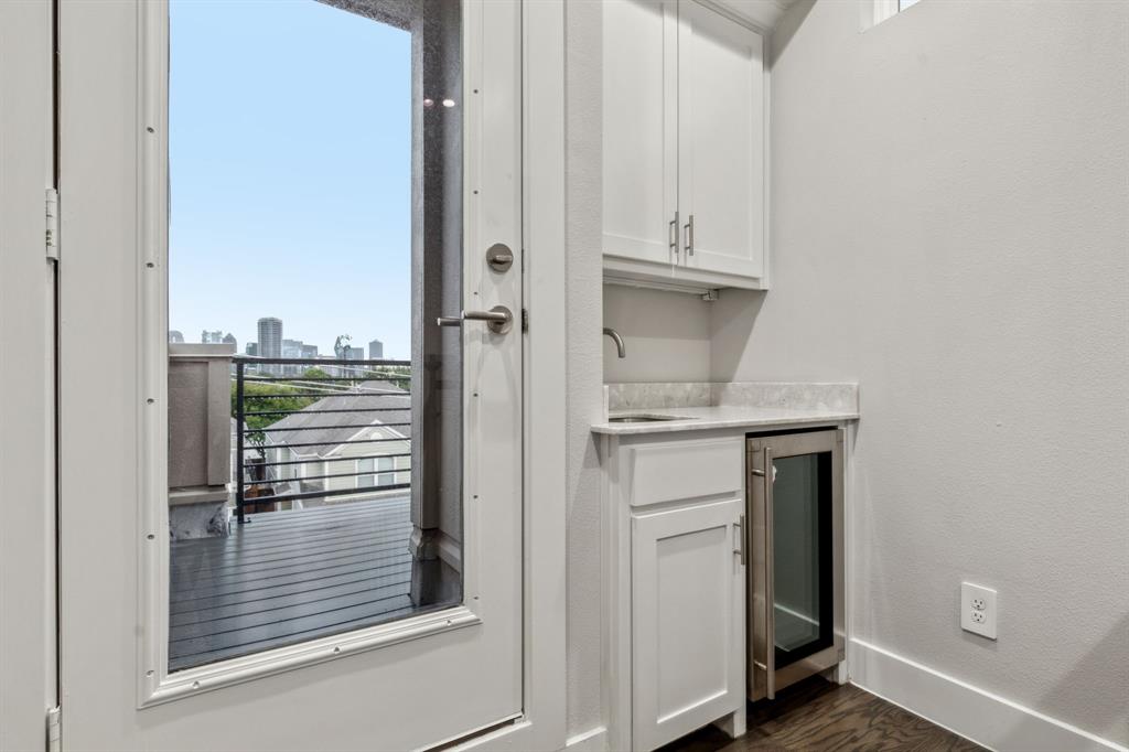 4109 Maison Ridge Dallas, TX 75219 - Photo 26 of 39 Entry to third floor terrace with sink, wine refrigerator, plenty of natural light, and dark hardwood / wood-style floors