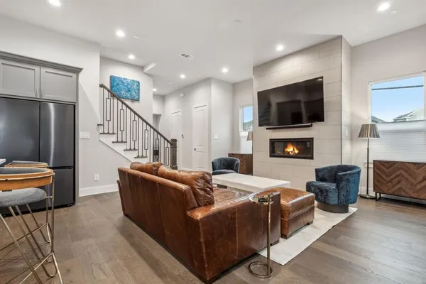 a living room with furniture a flat screen tv and a fireplace