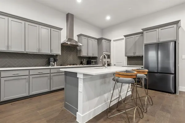 a kitchen with stainless steel appliances granite countertop a sink a stove and a refrigerator