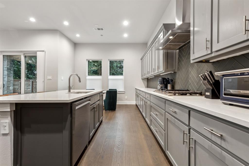 4109 Maison Ridge Dallas, TX 75219 - Photo 10 of 39 a kitchen with stainless steel appliances granite countertop a sink a stove and a wooden floors