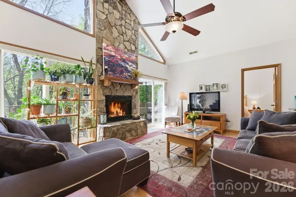 a living room with furniture a large window and a fireplace