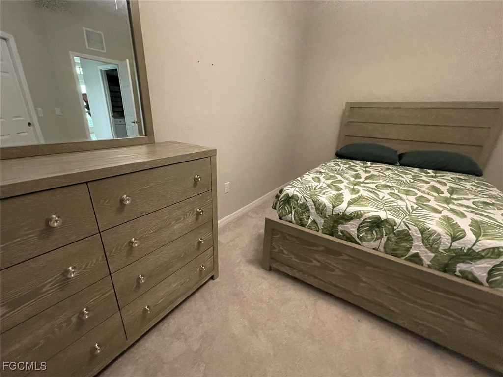 10529 Casella Way, Unit 102 Fort Myers, FL 33913 - Photo 11 of 14 a bedroom with a bed and a mirror