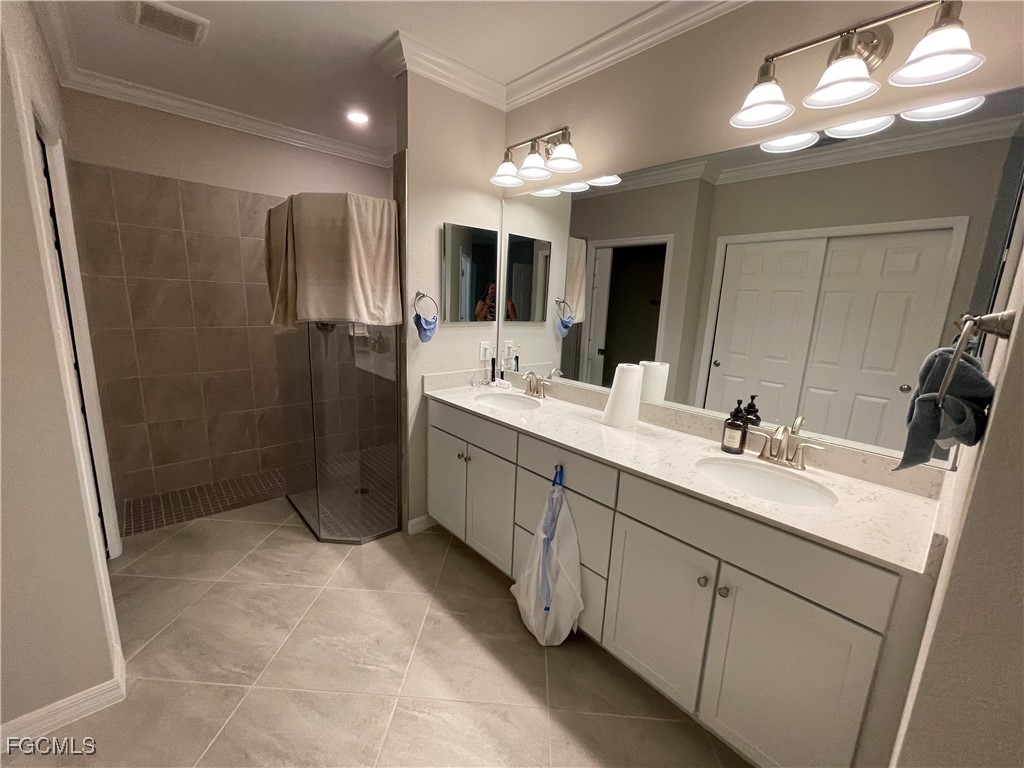 10529 Casella Way, Unit 102 Fort Myers, FL 33913 - Photo 13 of 14 a spacious bathroom with a double vanity sink a large mirror and a shower