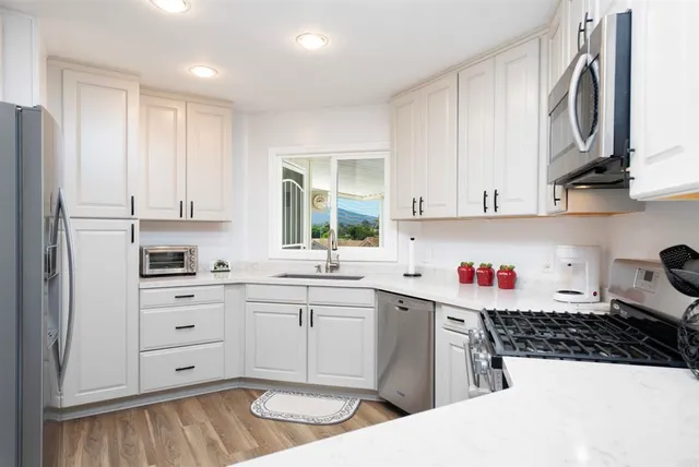 a kitchen with stainless steel appliances a white stove top oven sink and cabinets