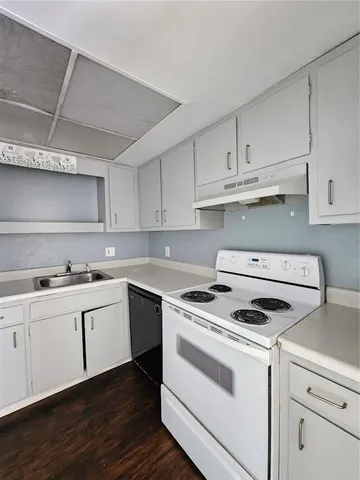 a kitchen with cabinets appliances a sink and a stove
