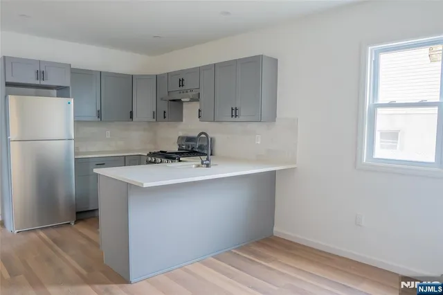 a kitchen with a sink a refrigerator and window