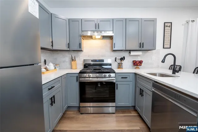 a kitchen with stainless steel appliances granite countertop a stove sink and cabinets