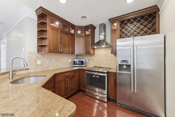 a kitchen with stainless steel appliances granite countertop a refrigerator and a sink