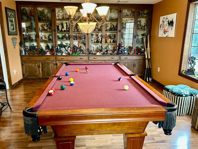 a room with pool table and windows