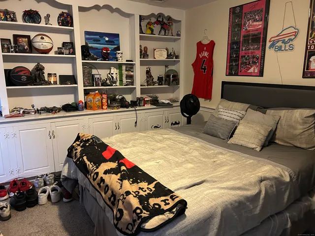 a bed sitting in a bedroom and book shelf