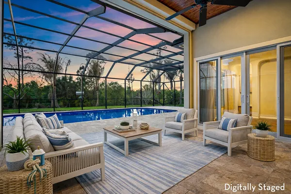a living room with patio furniture and a floor to ceiling window