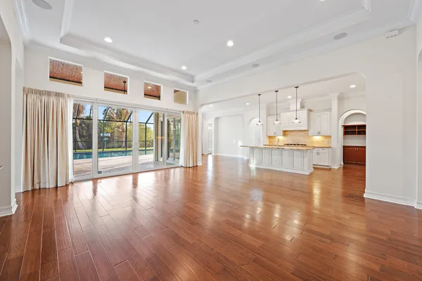 a view of a kitchen with wooden floor and a window