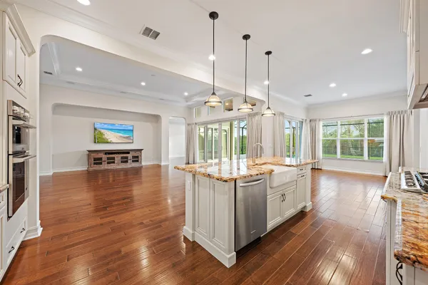 a open kitchen with stove a refrigerator and wooden floor