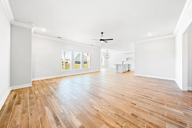 a view of empty room with wooden floor and windows