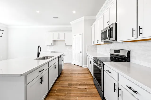 a kitchen with stainless steel appliances a sink dishwasher stove refrigerator and cabinets