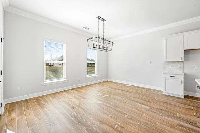 a view of empty room with wooden floor and windows