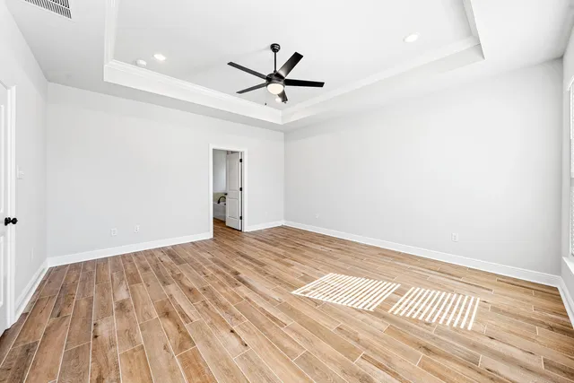 a view of a room with wooden floor and ceiling fan