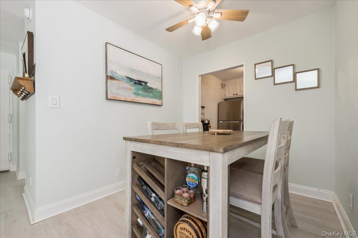 700 Shore Road, Unit 2E Long Beach, NY 11561 - Photo 18 of 31 a view of a dining room with furniture and a chandelier fan