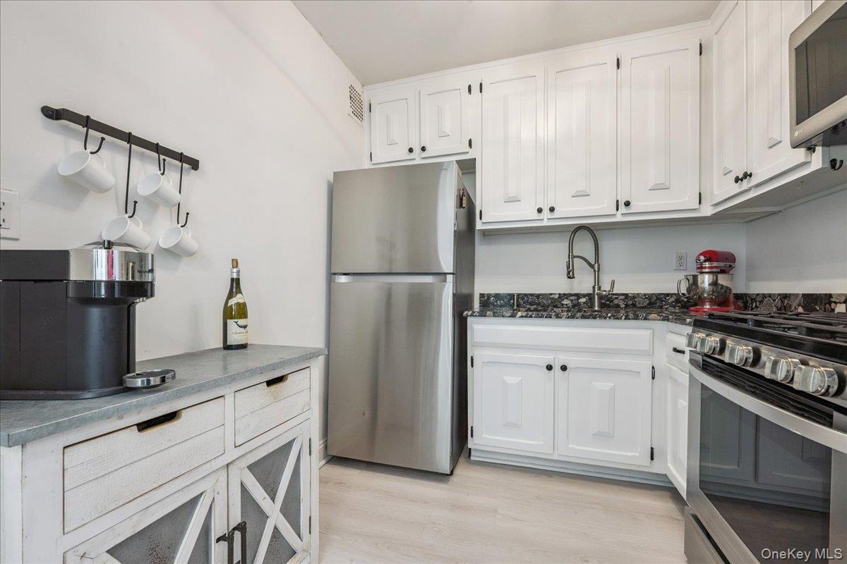 700 Shore Road, Unit 2E Long Beach, NY 11561 - Photo 19 of 31 a kitchen with cabinets stainless steel appliances and a counter space