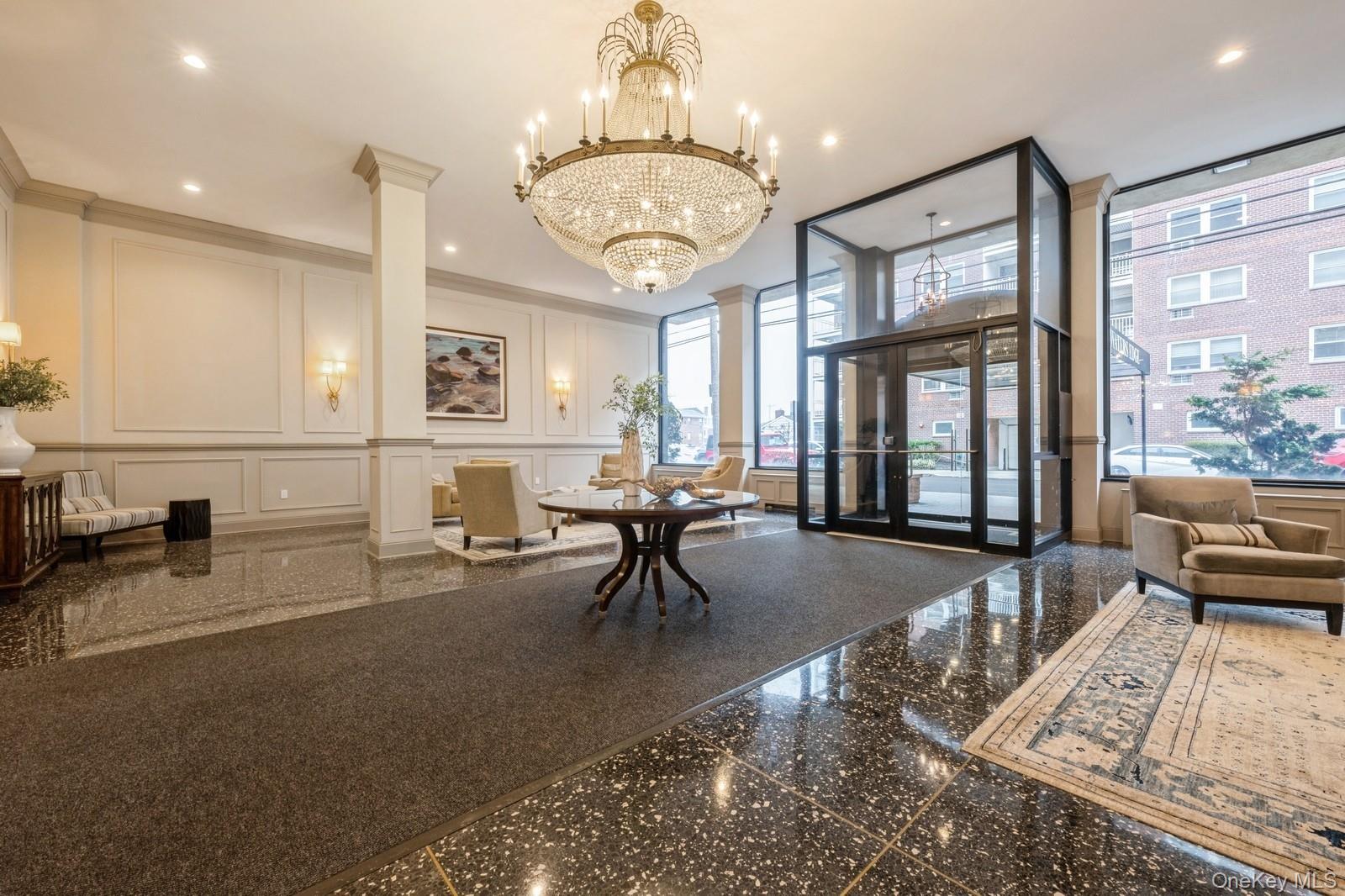 700 Shore Road, Unit 2E Long Beach, NY 11561 - Photo 4 of 31 a living room with furniture a chandelier and large window