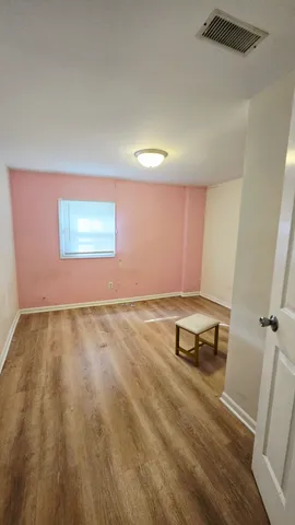 an empty room with a wooden floor and a window