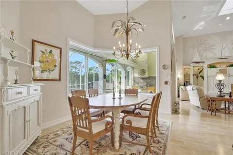 a view of a dining room with furniture a chandelier and wooden floor
