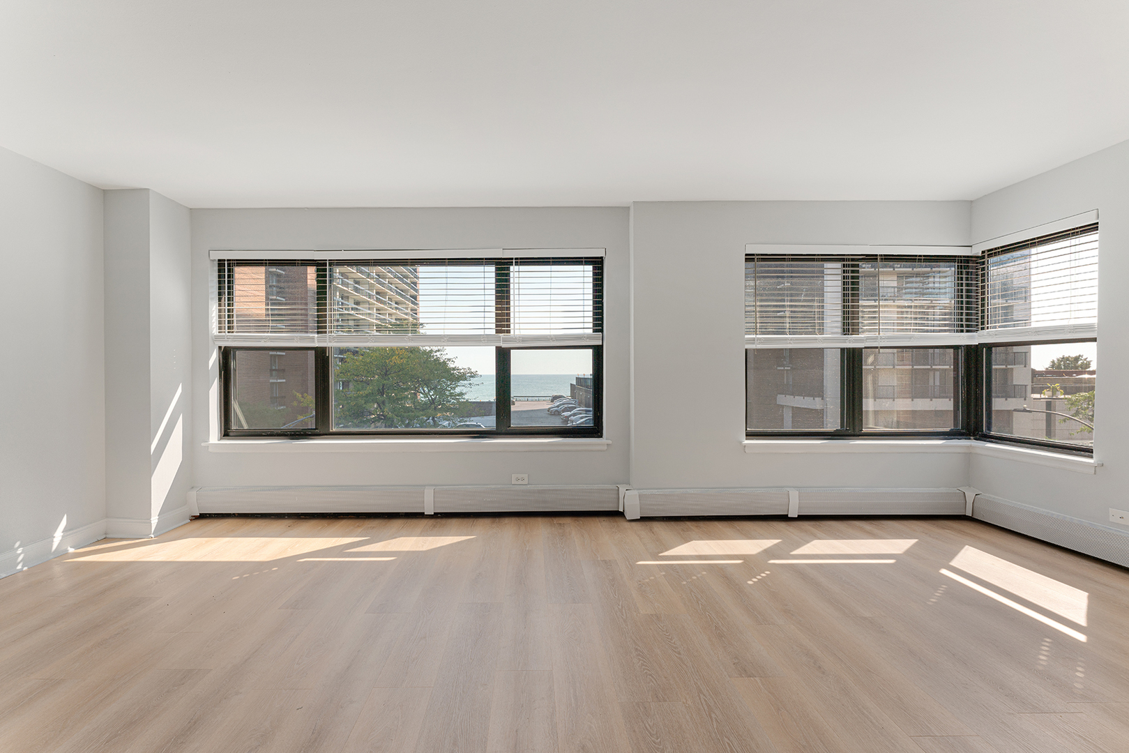 5858 North Sheridan Road, Unit 402 Chicago, IL 60660 - Photo 2 of 16 an empty room with wooden floor and windows