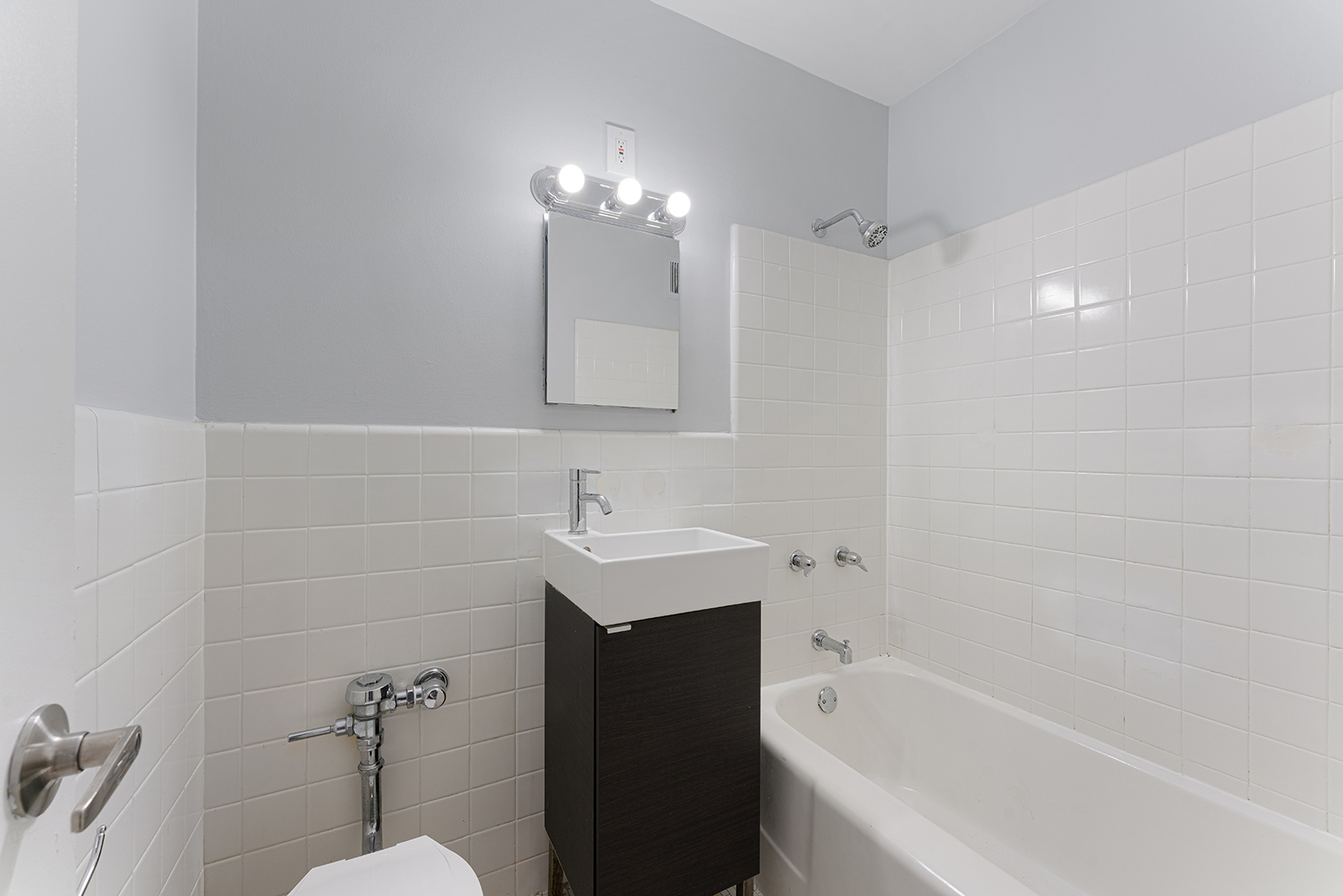 5858 North Sheridan Road, Unit 402 Chicago, IL 60660 - Photo 10 of 16 a bathroom with a bathtub shower sink vanity and a toilet