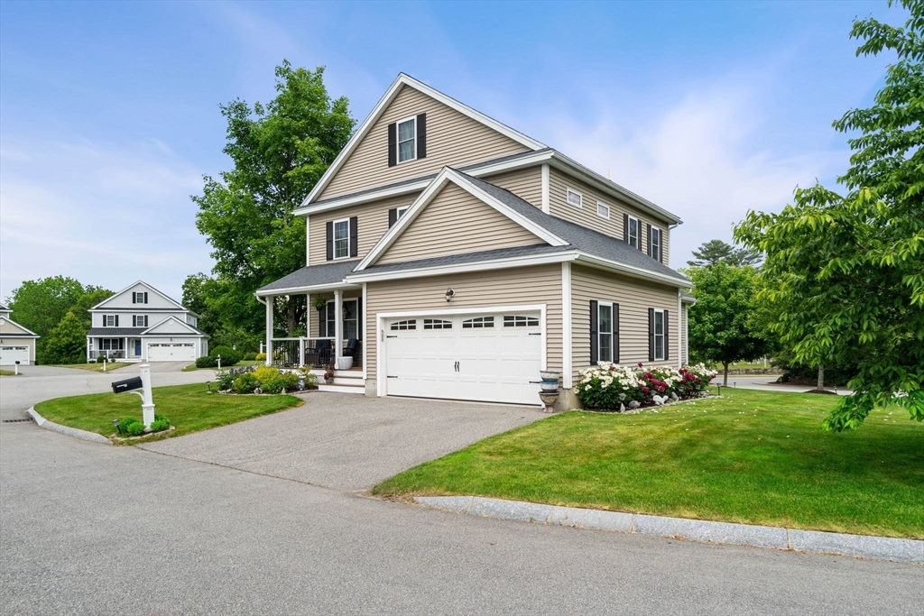 a front view of a house with a yard and trees