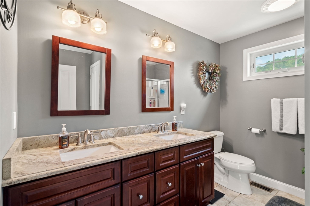 5 Comanche Circle, Unit 5 Haverhill, MA 01835 - Photo 15 of 29 a bathroom with a granite countertop sink vanity mirror and toilet