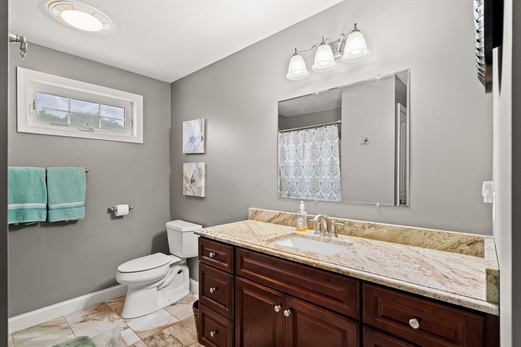 5 Comanche Circle, Unit 5 Haverhill, MA 01835 - Photo 16 of 29 a bathroom with a granite countertop toilet sink and mirror