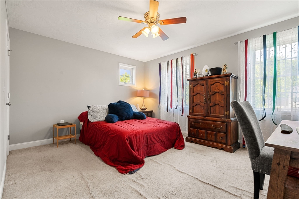 5 Comanche Circle, Unit 5 Haverhill, MA 01835 - Photo 21 of 29 a bedroom with a bed a dresser and a chandelier