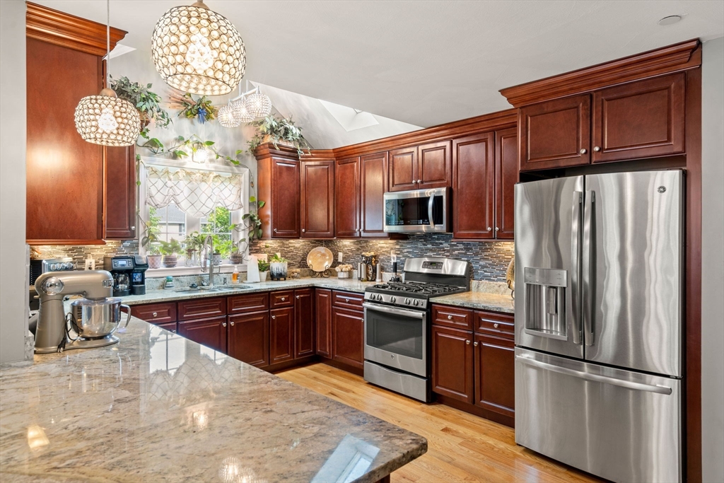 5 Comanche Circle, Unit 5 Haverhill, MA 01835 - Photo 4 of 29 a kitchen with stainless steel appliances granite countertop a sink refrigerator stove and microwave